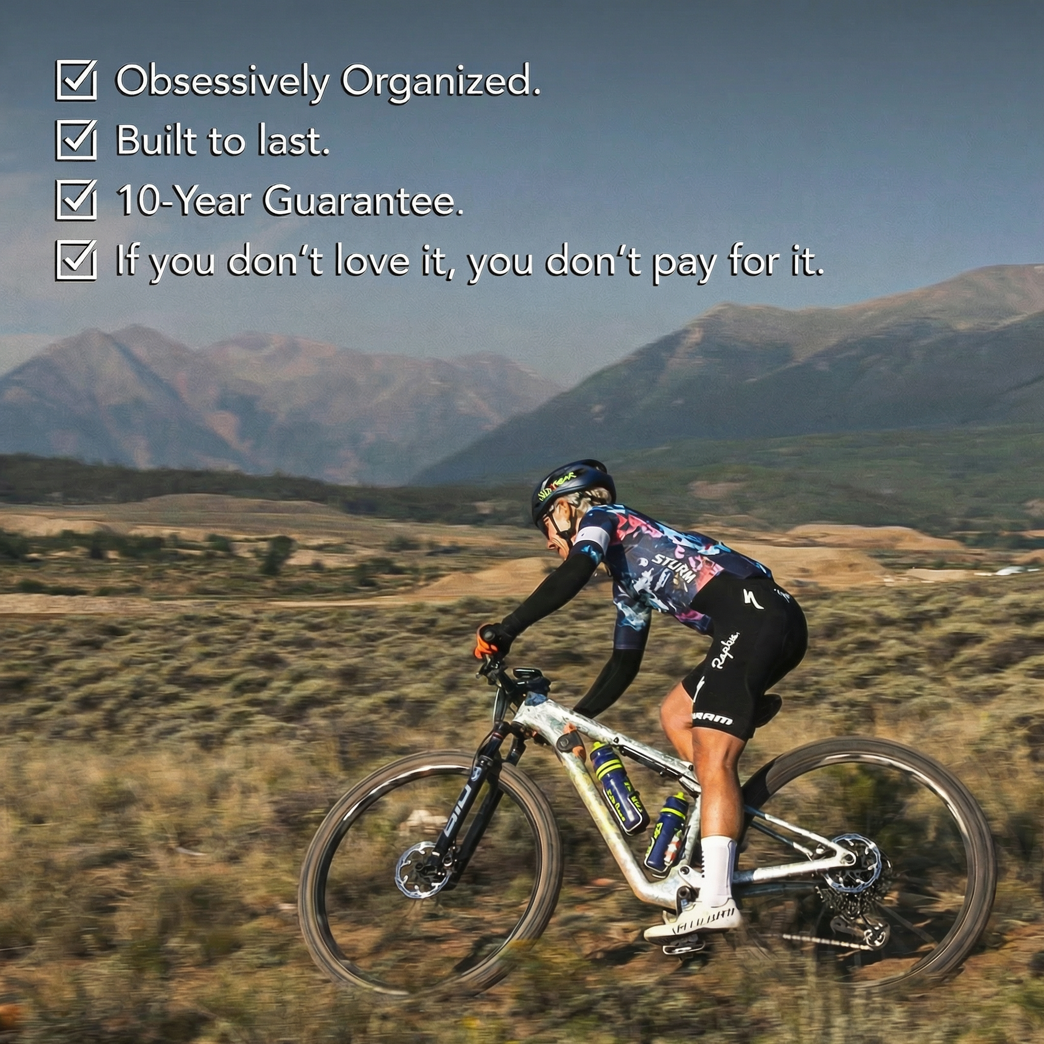 Cyclist racing a full-suspension mountain bike through a desert landscape with mountains behind them, with overlay text listing four product benefits: Obsessively Organized, Built to last, 10-Year Guarantee, and a satisfaction guarantee.